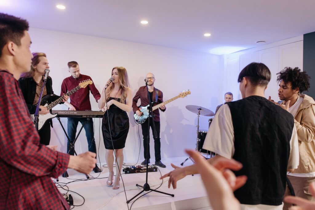 Woman singing karaoke with friends at a house party